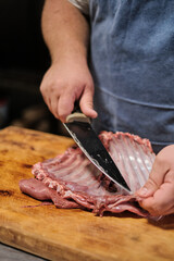 Wall Mural - The butcher cleans the lamb ribs. Preparing meat for smoking or barbecue