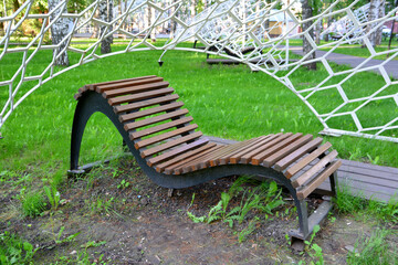 wooden bench in the park with white tent, close-up