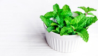 Mint leaf or Fresh mint herbs in a white bowl on white background