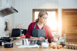 © vacancylizm - Beautiful young woman  is mixing batter, looking at camera and smiling while baking in kitchen at home ,decorating a cake of chocolate cake,cooking class, culinary, bakery, food and people concept