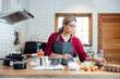 © vacancylizm - Beautiful young woman  is mixing batter, looking at camera and smiling while baking in kitchen at home ,decorating a cake of chocolate cake,cooking class, culinary, bakery, food and people concept