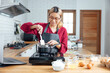 © vacancylizm - Beautiful young woman  is mixing batter, looking at camera and smiling while baking in kitchen at home ,decorating a cake of chocolate cake,cooking class, culinary, bakery, food and people concept