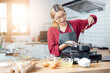 © vacancylizm - Beautiful young woman  is mixing batter, looking at camera and smiling while baking in kitchen at home ,decorating a cake of chocolate cake,cooking class, culinary, bakery, food and people concept