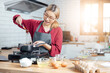 © vacancylizm - Beautiful young woman  is mixing batter, looking at camera and smiling while baking in kitchen at home ,decorating a cake of chocolate cake,cooking class, culinary, bakery, food and people concept