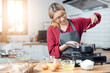 © vacancylizm - Beautiful young woman  is mixing batter, looking at camera and smiling while baking in kitchen at home ,decorating a cake of chocolate cake,cooking class, culinary, bakery, food and people concept