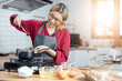 © vacancylizm - Beautiful young woman  is mixing batter, looking at camera and smiling while baking in kitchen at home ,decorating a cake of chocolate cake,cooking class, culinary, bakery, food and people concept