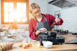 © vacancylizm - Beautiful young woman  is mixing batter, looking at camera and smiling while baking in kitchen at home ,decorating a cake of chocolate cake,cooking class, culinary, bakery, food and people concept