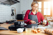 © vacancylizm - Beautiful young woman  is mixing batter, looking at camera and smiling while baking in kitchen at home ,decorating a cake of chocolate cake,cooking class, culinary, bakery, food and people concept