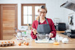 © vacancylizm - Beautiful young woman  is mixing batter, looking at camera and smiling while baking in kitchen at home ,decorating a cake of chocolate cake,cooking class, culinary, bakery, food and people concept