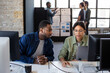 © ReeldealHD images - Coworkers looking at a desktop computer together