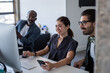 © ReeldealHD images - Coworkers looking at a desktop computer together on a videocall