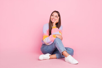 Wall Mural - Full size photo of cheerful charming girl hand touch cheek look empty space isolated on pink color background
