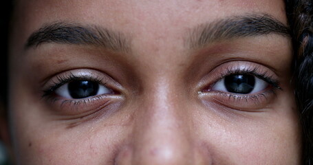 Wall Mural - Girl closing and opening eyes looking at camera, macro close-up teen girl african ethnicity