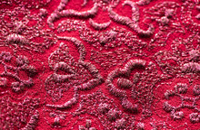 Red And Pink Fabric Texture Background With Embroided Pattern