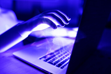 3D rendering of robot hand with laptop at table
