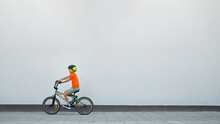 Boy Riding BMX Bike By White Wall