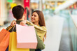 © Prostock-studio - Wife Embracing Husband Holding Shopper Bags Shopping In Mall
