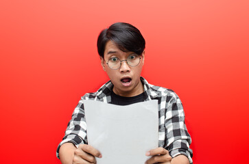 asian man with glasses shocked while holding blank paper work. asian man surprised by the letter on his hand.