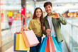 © Prostock-studio - Couple Showing Credit Card Posing With Shopper Bags In Hypermarket