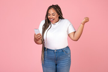 Wall Mural - Joyful Black Oversized Woman Using Smartphone Gesturing Yes, Pink Background