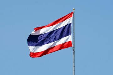 Sticker - thailand flag waving in wind in front of bright blue sky