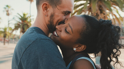 Close up, happy interracial family kisses outside