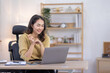 © David - Image of young indian pleased happy cheerful cute beautiful business Asian woman sit indoors in home office using laptop computer talking in a video conference on line