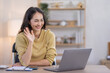 © David - Image of young indian pleased happy cheerful cute beautiful business Asian woman sit indoors in home office using laptop computer talking in a video conference on line