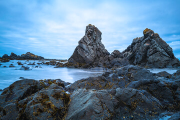 Wall Mural - Massive volcanic rocks towering on the beach at St. Geroge Point in Crescent City, California. Long exposure photography.