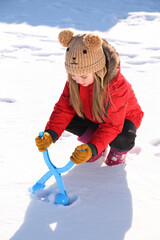 Wall Mural - Cute little girl playing with snowball maker outdoors