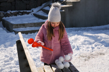 Wall Mural - Cute little girl playing with snowball maker outdoors