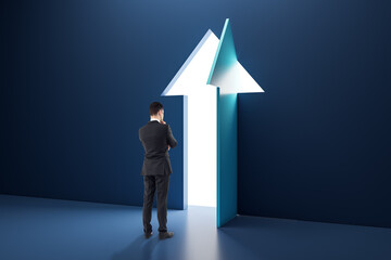 Poster - Back view of pensive businessman standing in interior with open arrow door. Success, business and opportunity concept.