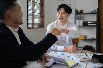 Wall Mural - Group of business people putting their hands working together on wooden background in office. group support teamwork agreement concept