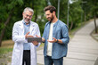 © zinkevych - Young man talking to a mature experienced doctor in a lab coat