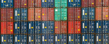 Stack Of Containers In A Harbor. Shipping Containers Stacked On Cargo Ship. Background Of Stack Of Containers At A Port.