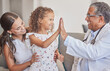 © Alexis Scholtz/peopleimages.com - Family, medical and high five with girl and doctor in consulting hospital room for healthcare, trust and support. Communication, medicine and smile with pediatrician consultant with mom and child