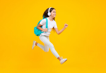 Wall Mural - Schoolgirl with backpack hold aplle ready to learn. School children with school bag on isolated yellow studio background. Excited teenager, jump and run, jumping child.