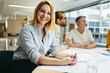 © Jacob Lund - Cheerful young designer sitting in a meeting with her colleagues