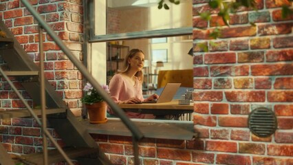 Aufkleber - Portrait of a Female Using Laptop Computer while Sitting Behind a Table in Her Stylish Living Room. Creative Manager Thinking, Brainstorming Different Business Ideas while Working Remotely from Home.