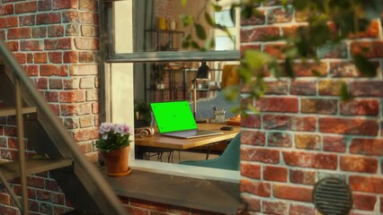 Fototapete - Laptop Computer with Green Screen Mock Up Display Standing on a Table in Stylish Living Room. View from Outside the Window of a Brooklyn-Style Brownstone Multi-Storey Building. Work from Home Concept.