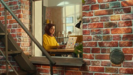 Poster - Young Muslim Female Student Using Laptop at Home. Attending Remote Education During the Day. Working on Computer, Writing an Essay Assignment. Arc Shot from Outside the Window.
