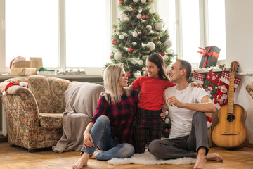 Wall Mural - Christmas family. Happy mom, dad and little daughter. Enjoyng love hugs, holidays people. Togetherness concept