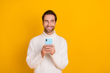 Sticker - Photo of cheerful dreamy guy dressed white sweater writing modern device empty space isolated yellow color background