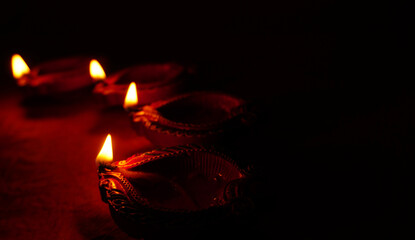 Oil lamps (Clay diya) lit on colorful rangoli during diwali celebration.Greeting Card Design Indian Hindu Light Festival called Diwali.