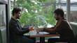 © Marco - Friends hanging out inside coffee shop looking at their cellphones. Two men staring at smartphone in cafe place