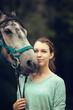 Young girl with grey horse. Portrait close up. Friendship with horse