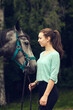Young girl with grey horse looking at each other. Portrait close up. Friendship with horse. Love, care