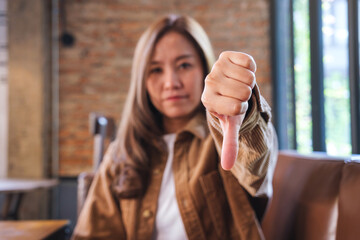 Wall Mural - A young woman making thumbs down hands sign