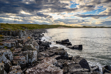 Canvas Print - Snook Point outcrop between Beadnell and Football Hole Bays, on the Northumberland coast, a designated Area of Outstanding Natural Beauty AONB, known for its wide beaches high sand dunes and whinstone