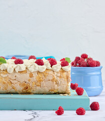 Wall Mural - Baked meringue roll with cream and fresh red raspberry, white background.